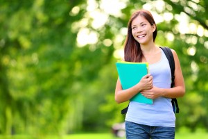 Student girl outdoor in park smiling happy going back to school.