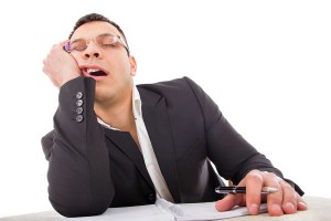 Exhausted Businessman Sleeping At His Desk Yawning