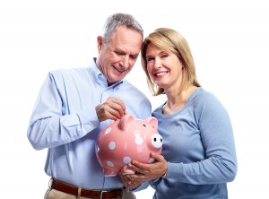 Happy senior couple with piggy bank. Isolated over white backgro