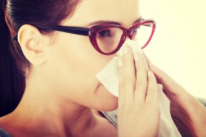 Young beautiful woman with tissue having runny nose.