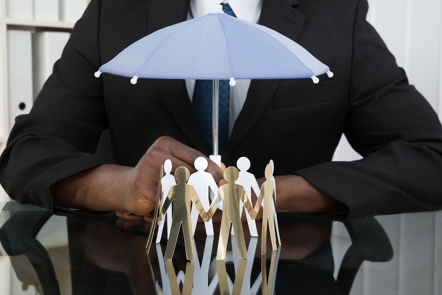 Businessman Holding Umbrella Over Paper Cutout People
