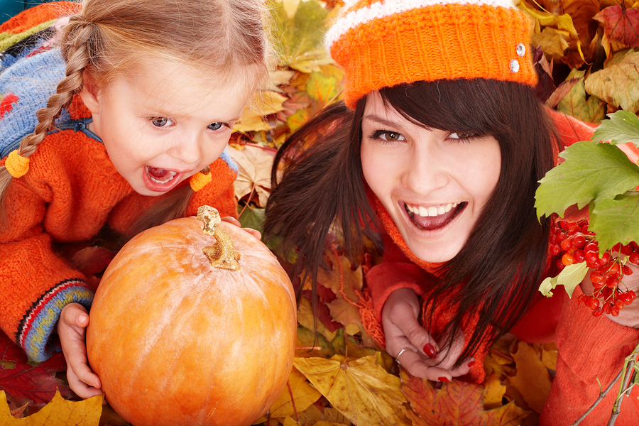 Happy family with  pumpkin on autumn leaves. Outdoor.