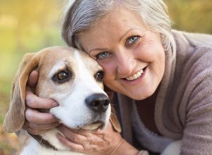 Active senior woman hugs dog