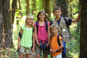 Four children in woods with camping gear