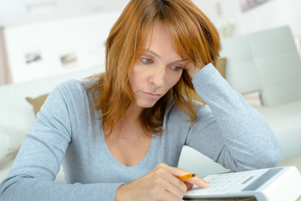 Lady using calculator, stressed