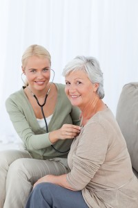 Nurse taking the heartbreat of her patient at home