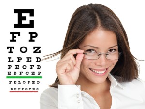 Optician or optometrist wearing glasses standing by Snellen eye