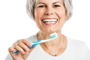 Portrait of a happy old woman brushing her teeth