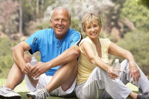 Senior Couple Resting Aftre Exercising In Park